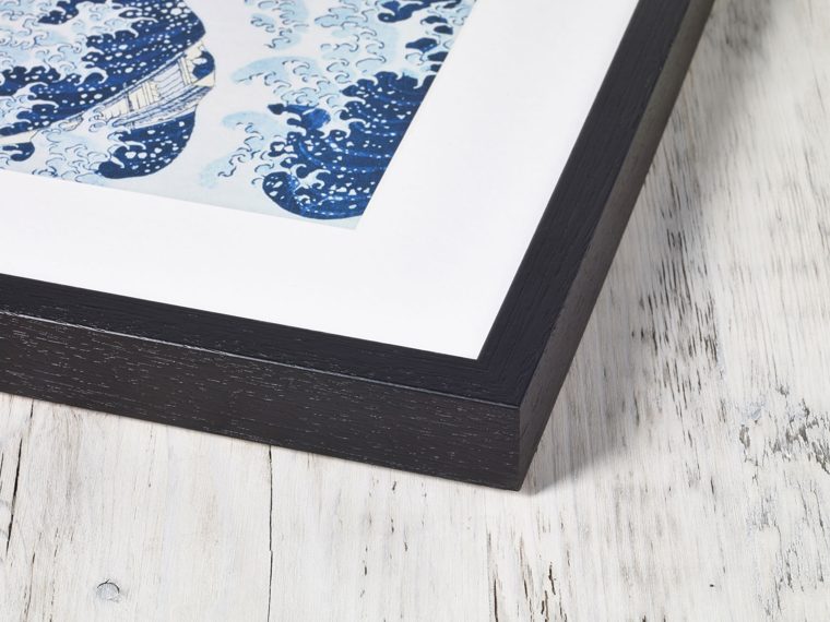 Corner detail of a dark wood box frame holding a poster print